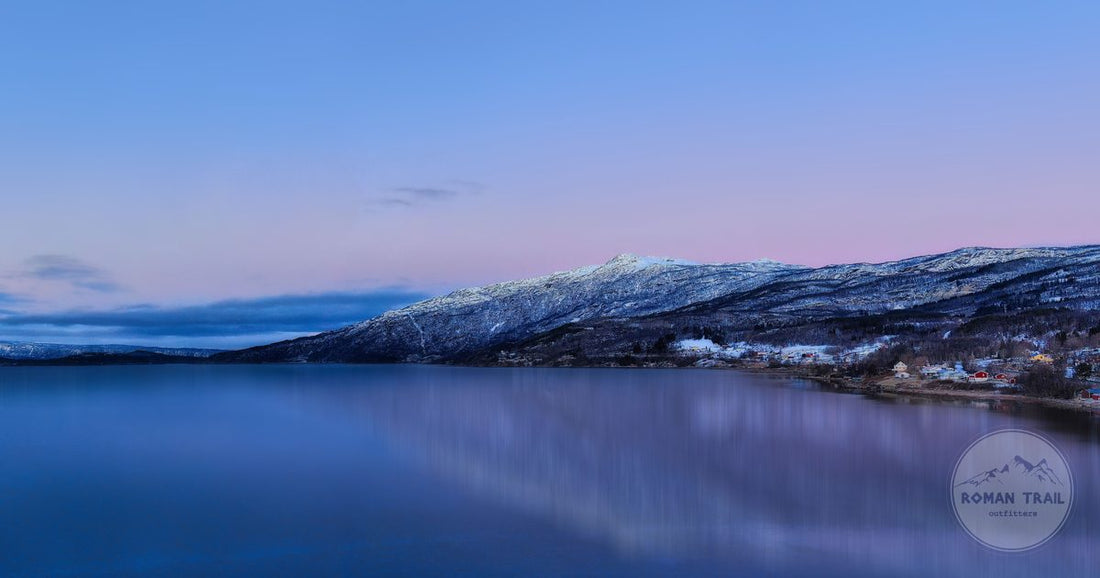 A frozen lake at dawn below snow covered mountains at Abisko, Sweden