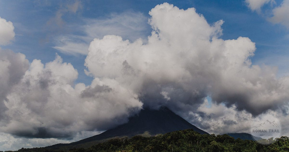 The cone of Arenal volcano above the lake and rainforest in Costa Rica, Arenal packing list for women by Roman Trail Outfitters