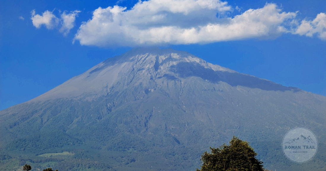Mount Meru under cloud above green country near Arusha, Arusha packing list for women by Roman Trail Outfitters
