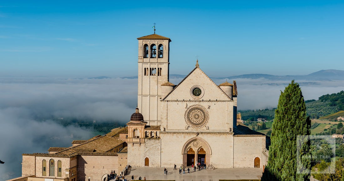 The Basilica di San Francesco above misty hills at Assisi, Italy