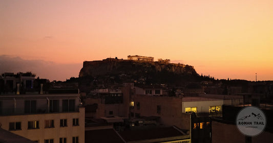 The Acropolis silhouetted above Athens rooftops at sunset, Athens packing list for women by Roman Trail Outfitters