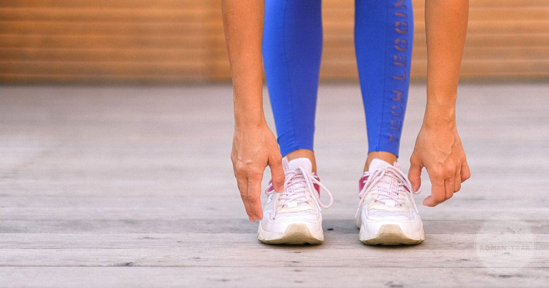 A sportswoman in close fitting leggings stretching