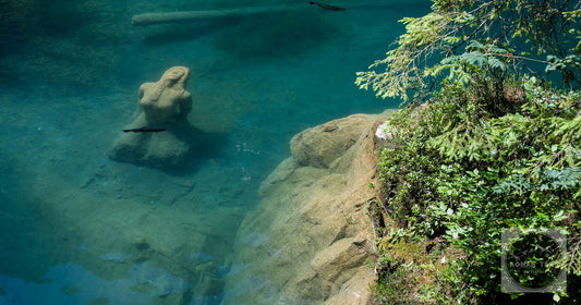 An underwater statue in the clear blue water of the Blausee, Switzerland