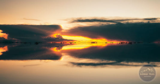 The mirror reflection of a golden sunset sky on the Salar de Uyuni salt flat, Bolivia
