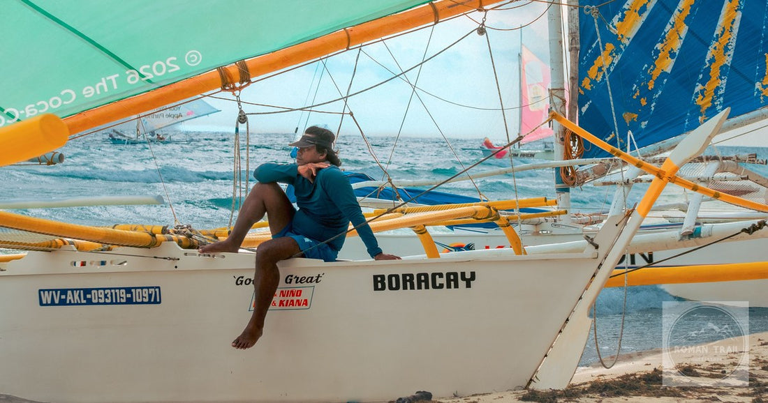A sailor on a traditional paraw sailboat on the sand at Boracay, Philippines