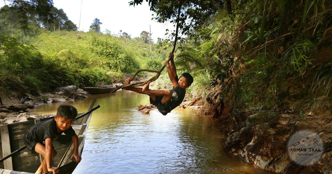 Boys playing by a river in the jungle of North Sumatra, Indonesia