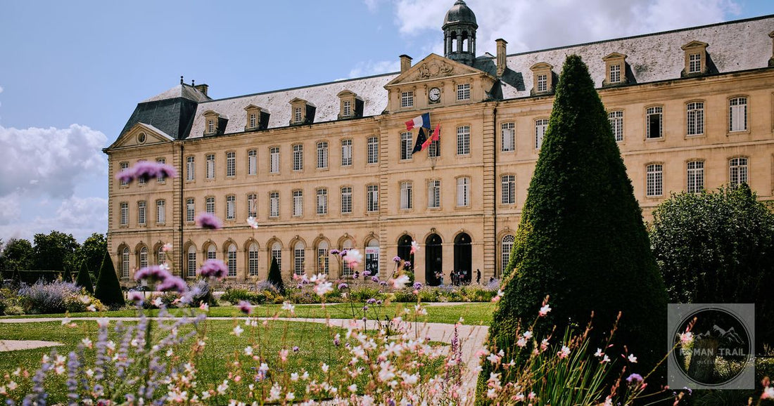 Stunning view of Abbaye aux Hommes with vibrant gardens in Caen, Normandy under a bright blue sky.