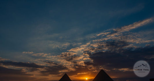 The Giza pyramids silhouetted against a sunset sky, Cairo, Egypt