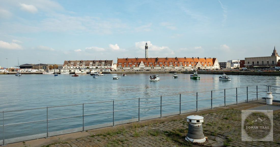 Charming Calais harbor view with small boats, historic buildings, and blue sky.