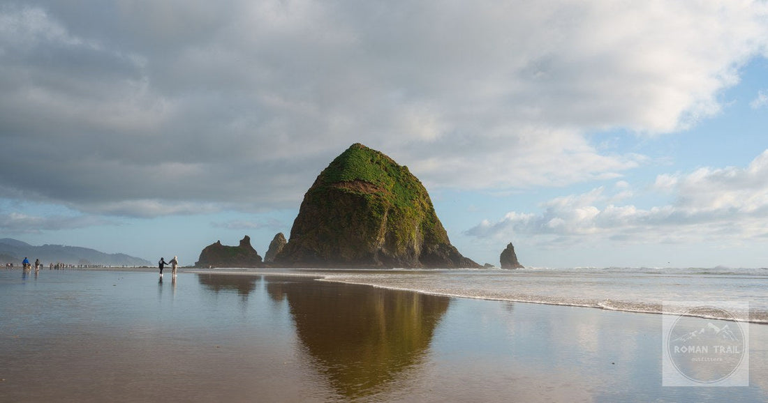 Captivating view of Haystack Rock reflecting on wet sand at Cannon Beach, Oregon.