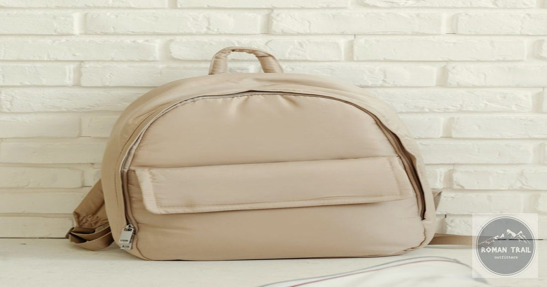 Minimalist beige carry-on backpack against a white brick wall, carry-on only packing list for women by Roman Trail Outfitters