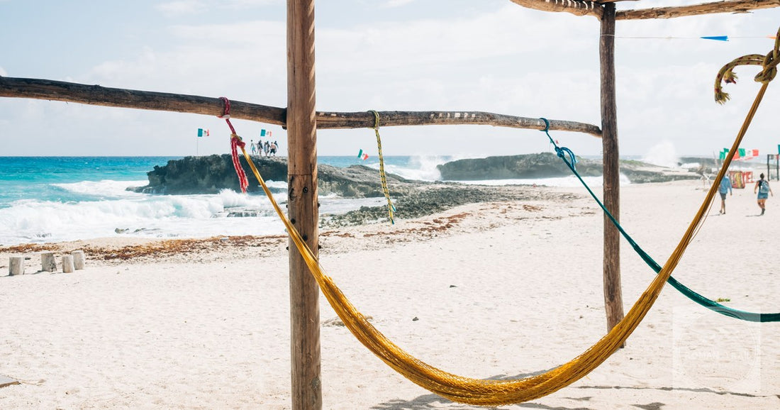 A hammock on a sandy beach with turquoise water at Cozumel, Mexico