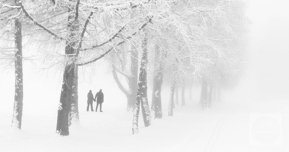 A couple walking through snow-covered forest at Crans-Montana, Switzerland