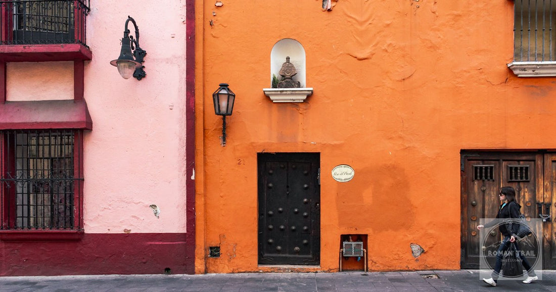 A colorful facade and a passer by on a sunny street in Cuernavaca, Mexico