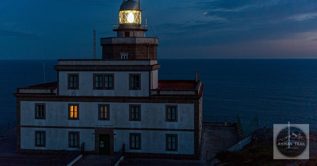 Night view of Cape Finisterre lighthouse in Spain overlooking the ocean.