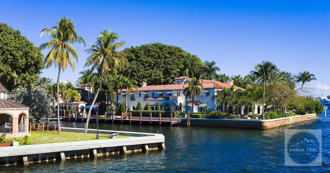 Beautiful tropical homes along a canal with palm trees and clear blue sky in Fort Lauderdale, Florida.