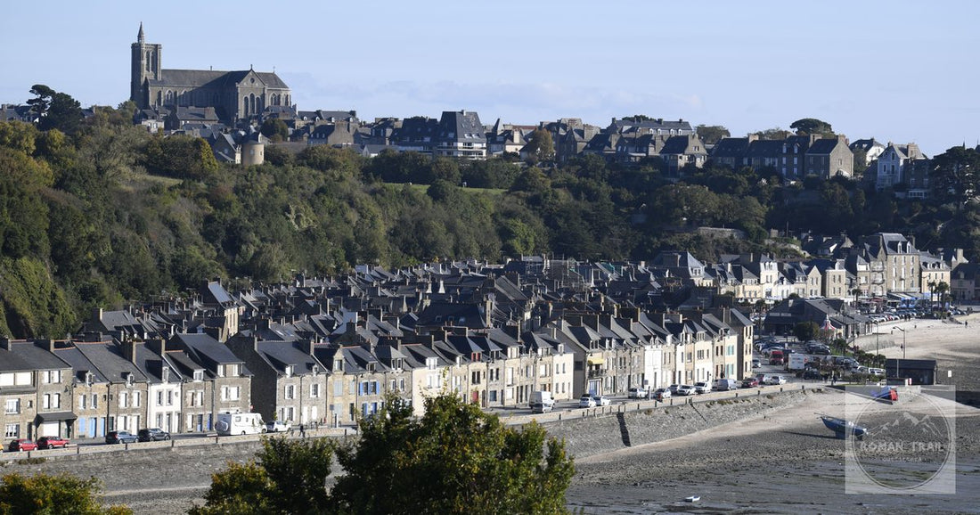 A scenic view of Granville, France, showcasing coastal houses and a historic church.