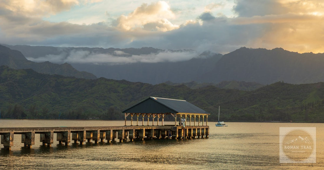 Picturesque view of Hanalei Pier with mountains and sunset in Kauai, Hawaii.