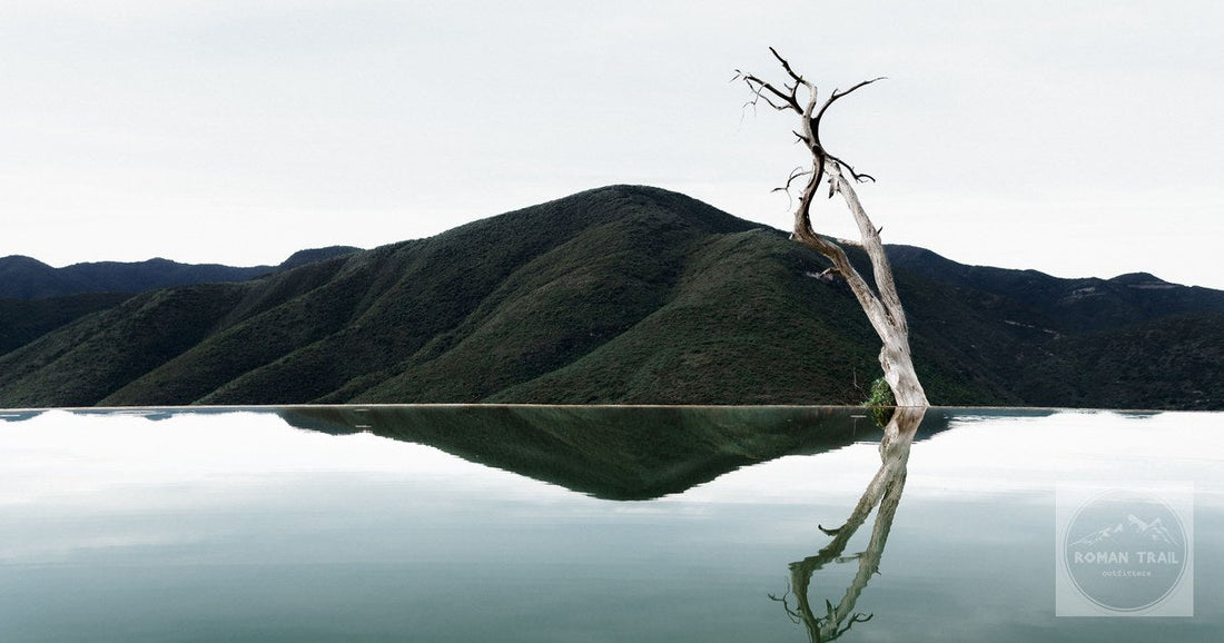 Stunning photograph of Hierve el Agua with reflecting waters and mountains in Oaxaca, Mexico.