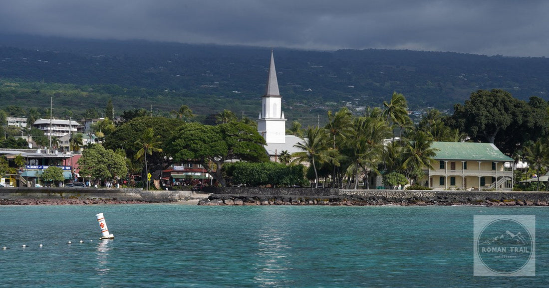 Scenic view of Kailua-Kona waterfront featuring a historic church under cloudy skies.