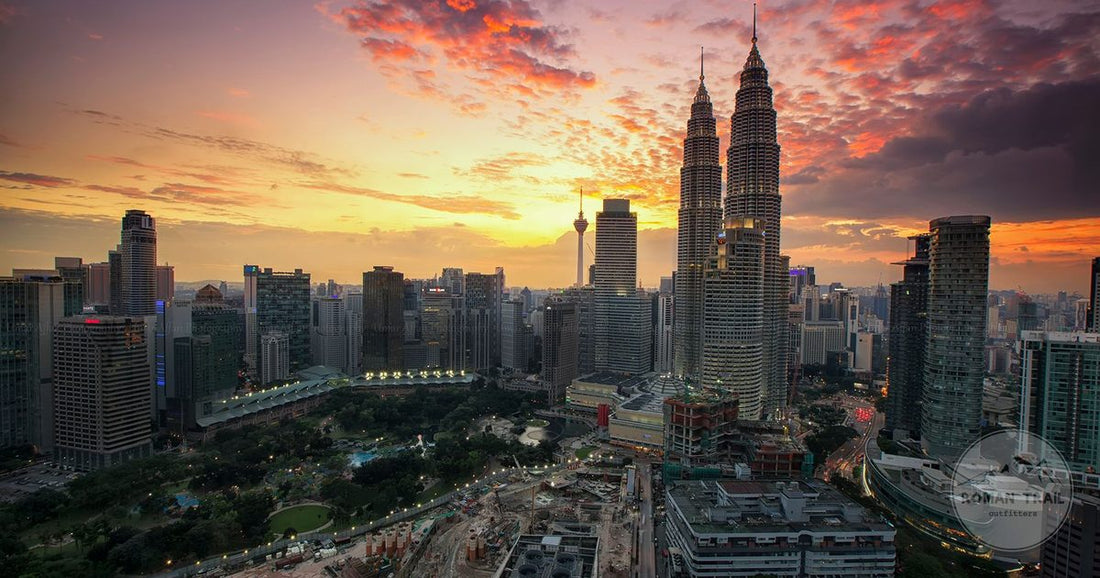 Kuala Lumpur skyline with the Petronas Towers and KL Tower under a dramatic sunset, Kuala Lumpur packing list for women by Roman Trail Outfitters