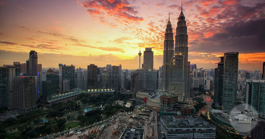 Kuala Lumpur skyline with the Petronas Towers and KL Tower under a dramatic sunset, Kuala Lumpur packing list for women by Roman Trail Outfitters