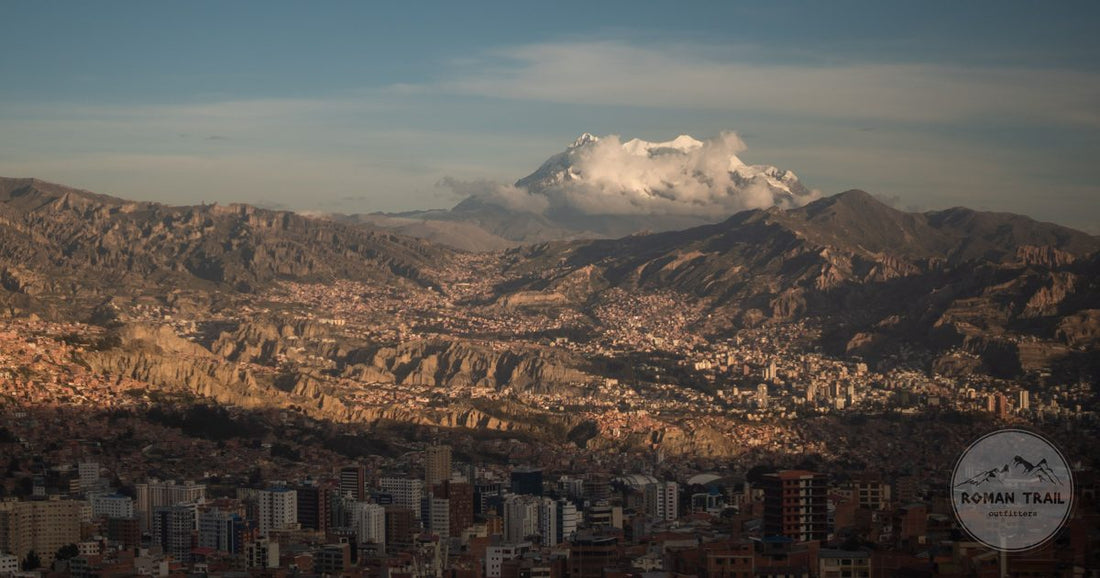 The city of La Paz filling its canyon bowl with snow capped Illimani behind it, La Paz packing list for women by Roman Trail Outfitters
