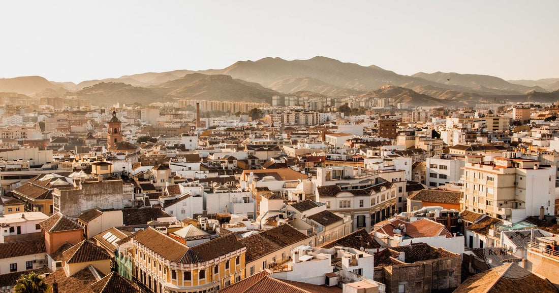 Aerial view of Malaga with the coast and the mountains behind it, Malaga packing list for women by Roman Trail Outfitters