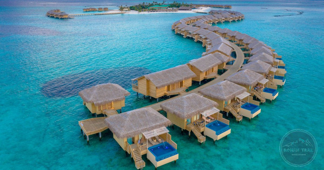 Overwater bungalows curving across a turquoise lagoon at golden hour in the Maldives