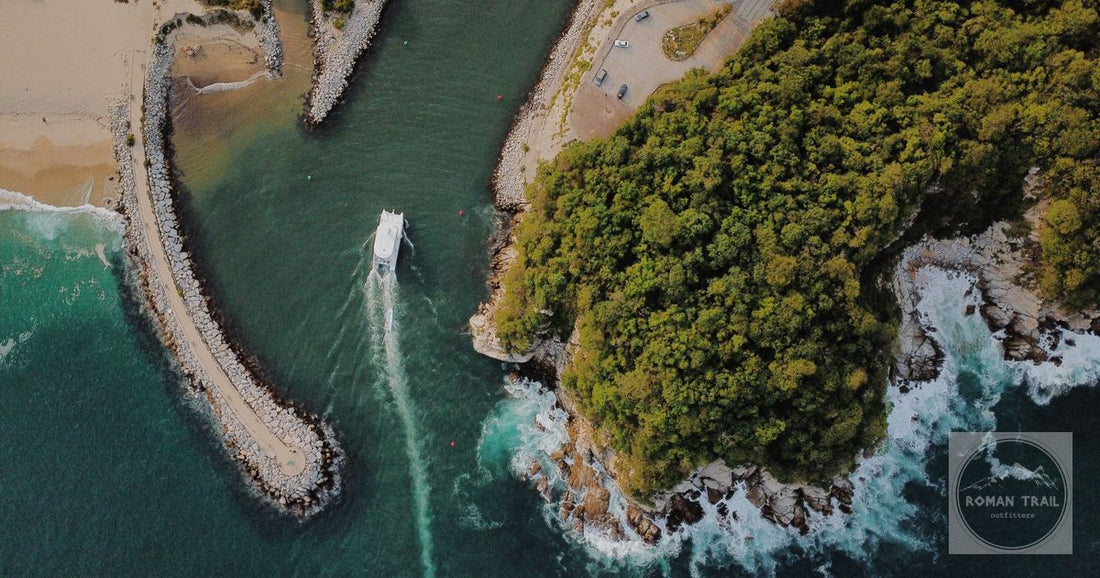 Stunning aerial view of Mazunte's coastline with a boat navigating through the turquoise sea and lush gr