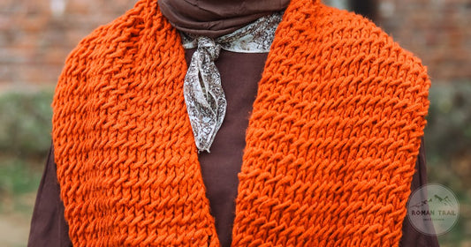 A knitted scarf worn over a brown outfit in autumn colours