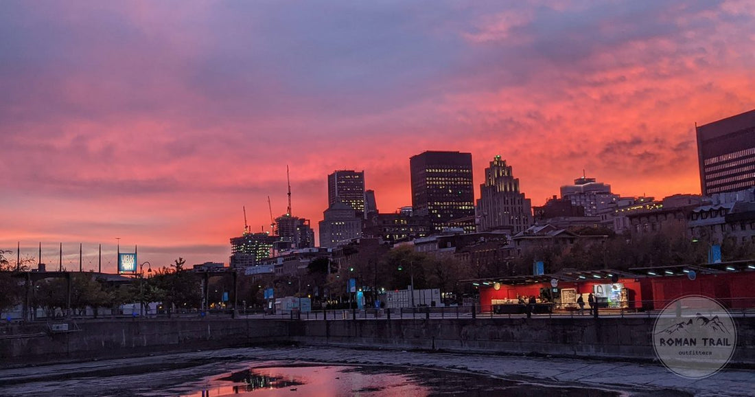 Montreal skyline under a dramatic sunset reflected in the St Lawrence, Montreal packing list for women by Roman Trail Outfitters