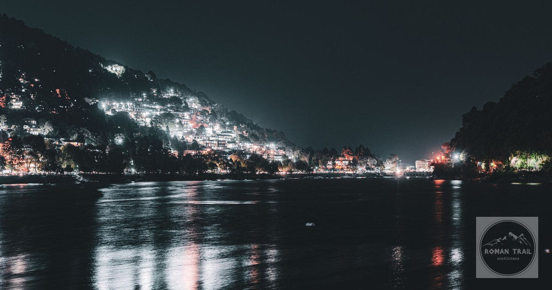 Stunning nighttime view of Nainital Lake with the illuminated town reflecting in the water.