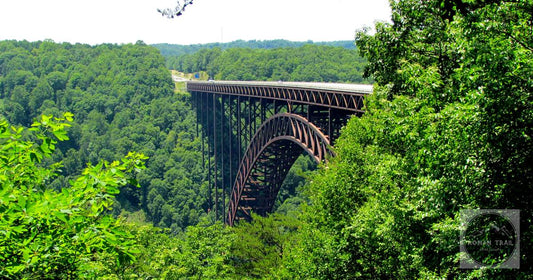 The steel arch of the New River Gorge Bridge above the forested gorge, West Virginia