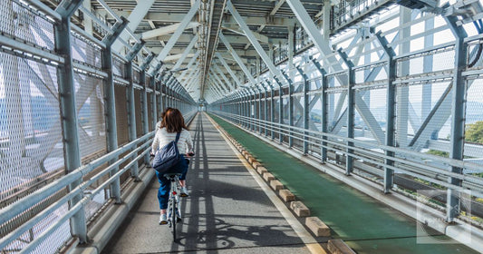 A woman cyclist rides on the Innoshima Bridge in Onomichi, Japan, showcasing the engineering marvel.