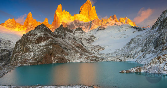Fitz Roy mountain in Patagonia Argentina glowing orange at sunrise above a turquoise glacial lake, women's Argentina packing list by Roman Trail Outfitters