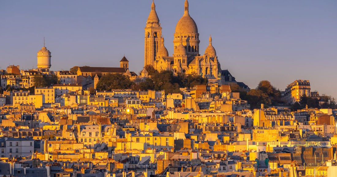 Sacre-Coeur Basilica and Montmartre rooftops bathed in golden hour light in Paris - Roman Trail Outfitters France packing list