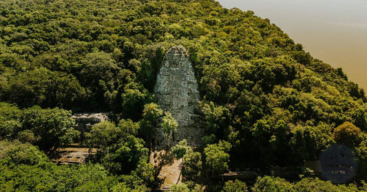 Mayan pyramid temple rising above the jungle canopy at Tikal, Guatemala, women's packing list by Roman Trail Outfitters