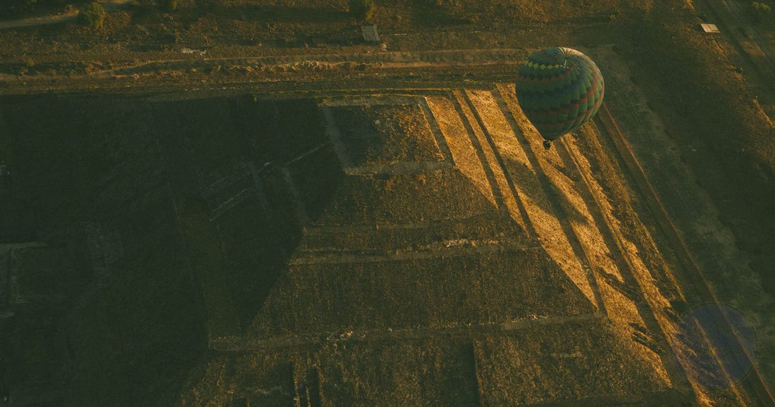 Aerial view of a hot air balloon casting long shadows over the Pyramid of the Sun at Teotihuacan, Mexico at golden hour, women's travel destination