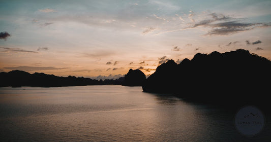 Limestone karst silhouettes at sunset in Halong Bay, Vietnam, women's travel destination