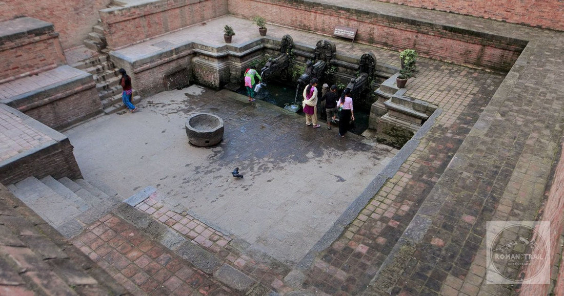 People gathered around the historic stone water spouts at Patan, Nepal