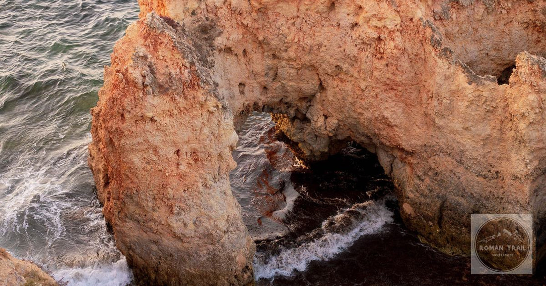 A natural stone arch by the ocean in Portimão, Portugal, showcasing rugged coastal beauty.