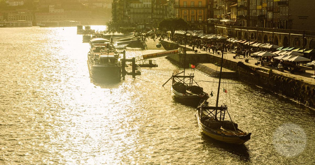 Rabelo boats on the Douro below the Ribeira waterfront in Porto at golden hour, Porto packing list for women by Roman Trail Outfitters