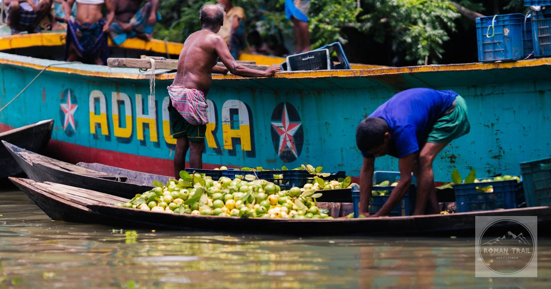 Men selling fruit from boats on a river at Rajshahi, Bangladesh