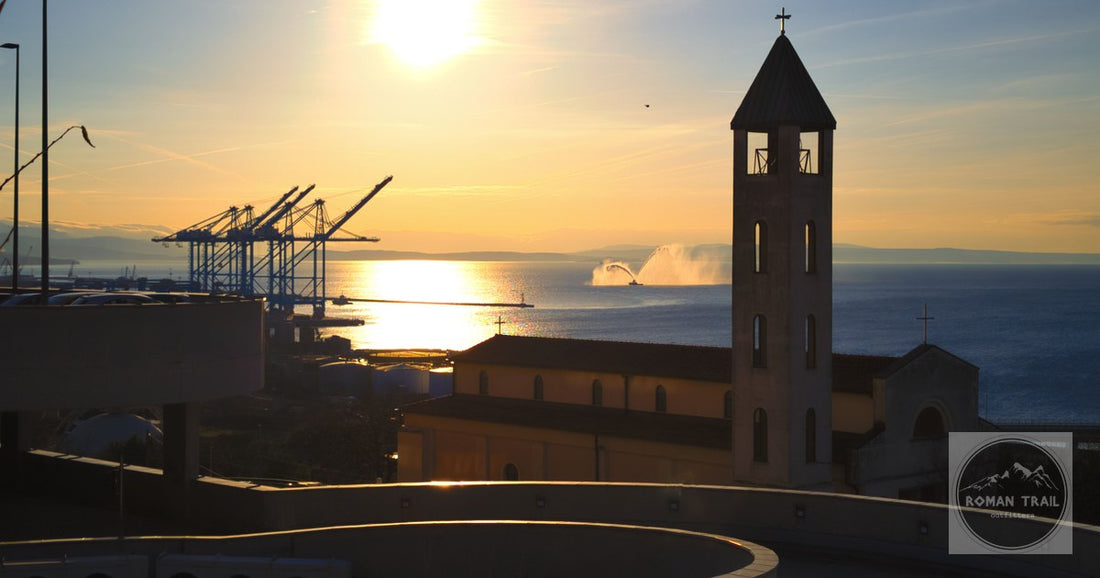 Sunset over the port at Rijeka, Croatia, with a church tower