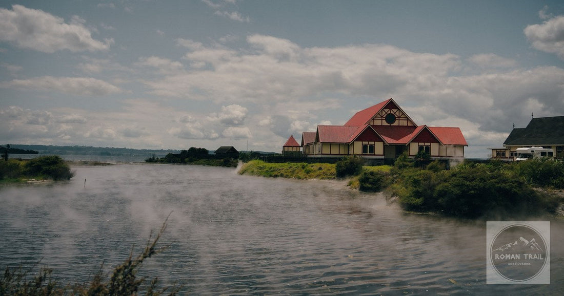 A traditional Maori building by Lake Rotorua with geothermal steam behind it