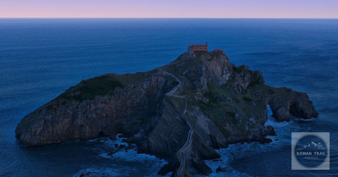 A breathtaking aerial view of Gaztelugatxe's rocky island linked by a winding path at twilight.
