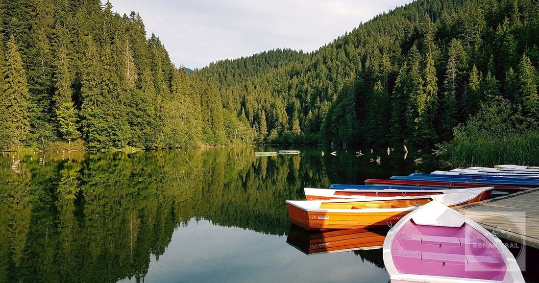 Rowing boats on Lake Ursu at Sovata, Romania, with forest reflected in the heliothermal water.