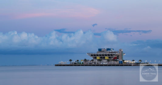 Twilight view of the iconic St. Pete Pier with reflections on the calm water in St. Petersburg, Florida.