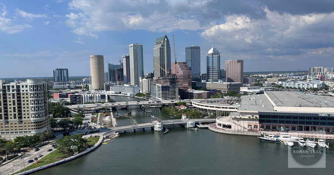 Stunning aerial view of downtown Tampa's skyline along the waterfront under a bright daytime sky.